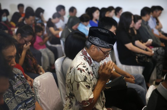 Relatives of passengers onboard AirAsia flight QZ8501 pray together in a waiting area at Juanda International Airport in Surabaya